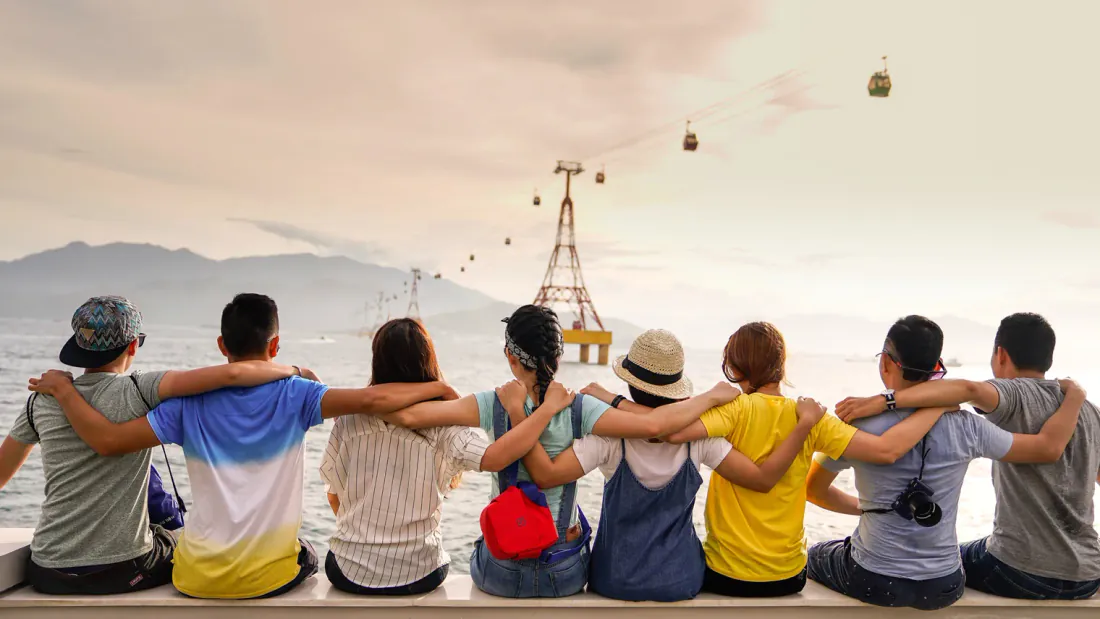 People sitting on a wall with their arms around each other